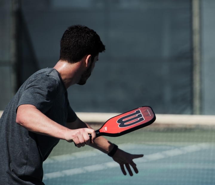 Man holding paddle playing pickleball